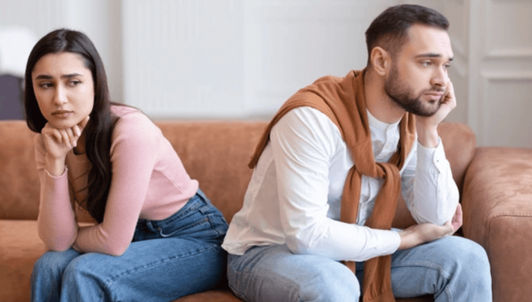 a man and woman sitting on a couch martin pe coach de parejas