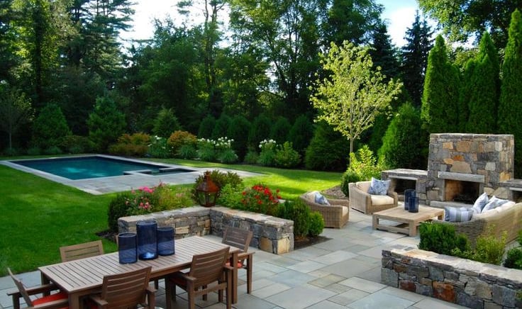 a patio with a table and chairs and a fireplace