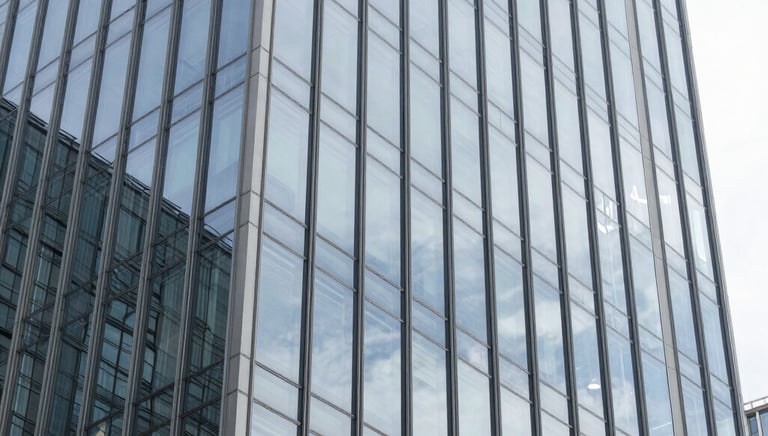 Modern commercial building with sleek glass facade reflecting the sky