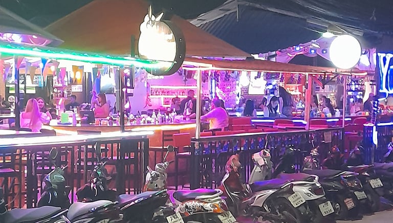 Outside view of bars at Wonderland bar complex in Hua Hin under neon lights