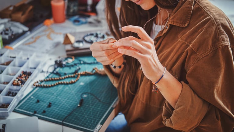 artesana haciendo collar con cuentas en su taller