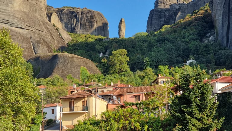 Kastraki village houses below the towering Meteora rock formations and vertical cliffs in Greece.