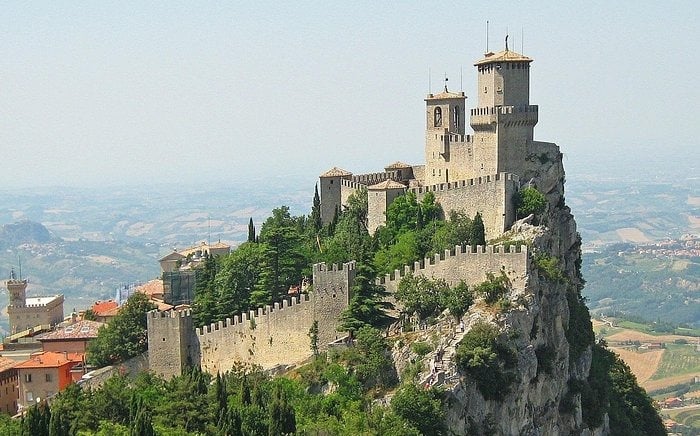 The historic Guaita Tower fortress sits atop Mount Titano in San Marino overlooking the valley.