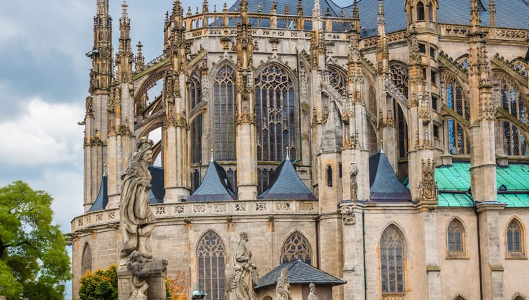 Gothic architecture of St. Barbara's Cathedral in Kutna Hora with ornate flying buttresses and stone statues.