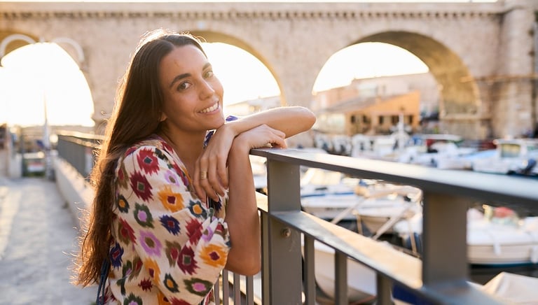 a girl posting for a portrait with vallon des auffes bridge in the background