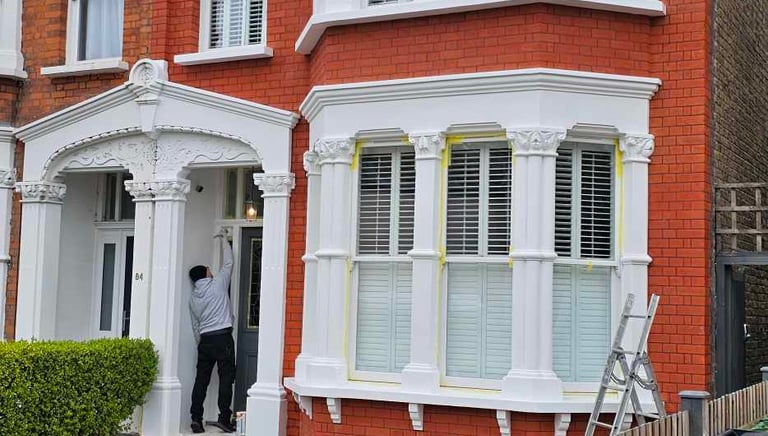 Exterior painting of red-brick house with white detailing in Balham, done by Pure Perfection