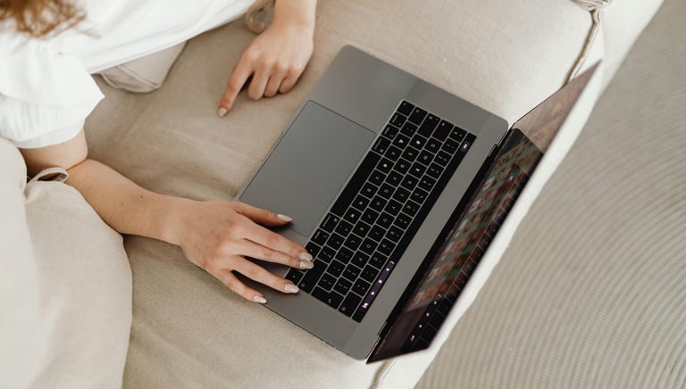 a woman sitting on a couch with her laptop