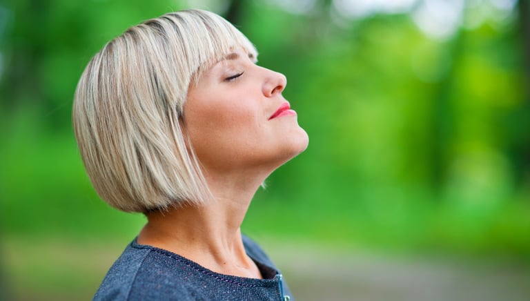 Photo d'une femme qui respire en toute conscience les yeux fermés lors d'une séance de sophrologie