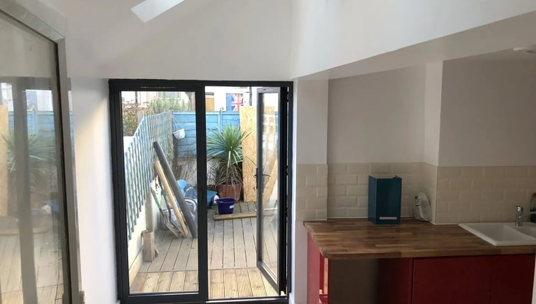 Modern rear house extension with bifold doors opening to garden in Brighton by T.L.E Constructing.