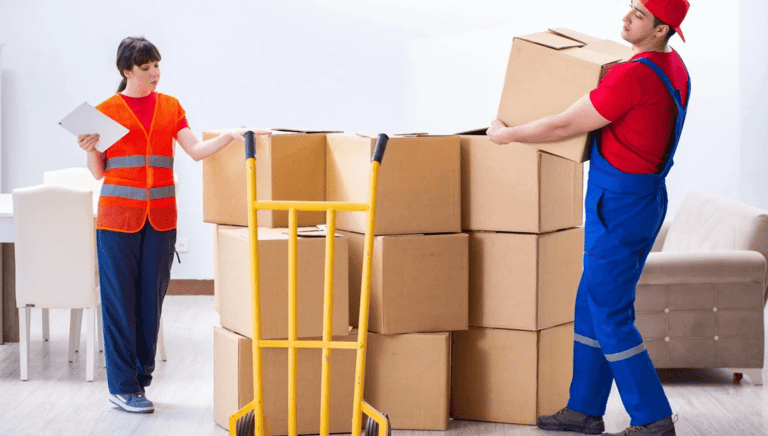 a man and woman moving boxes in a living room