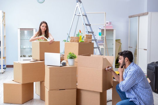 a man and woman moving boxes to move