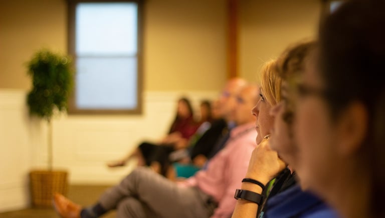 an adult education classroom, people sitting in a row of chairs