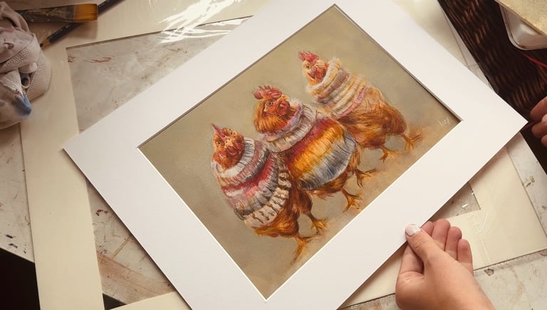 An art print by Alex Goddard showing a trio of chickens wearing colourful sweaters.