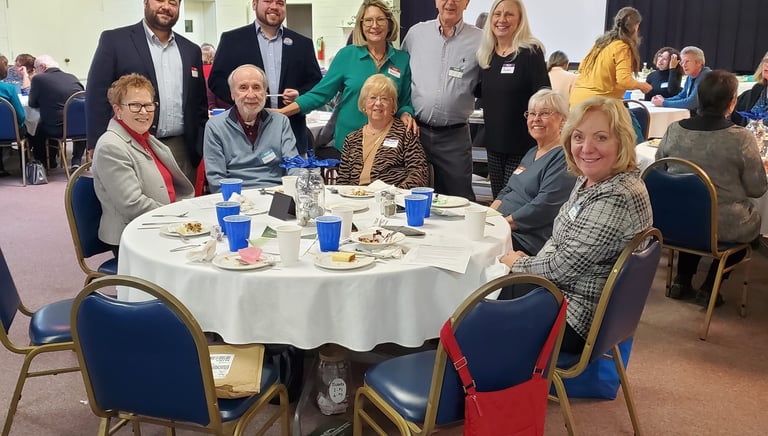 Smiling neighbors gathered around a table at a fundraising event