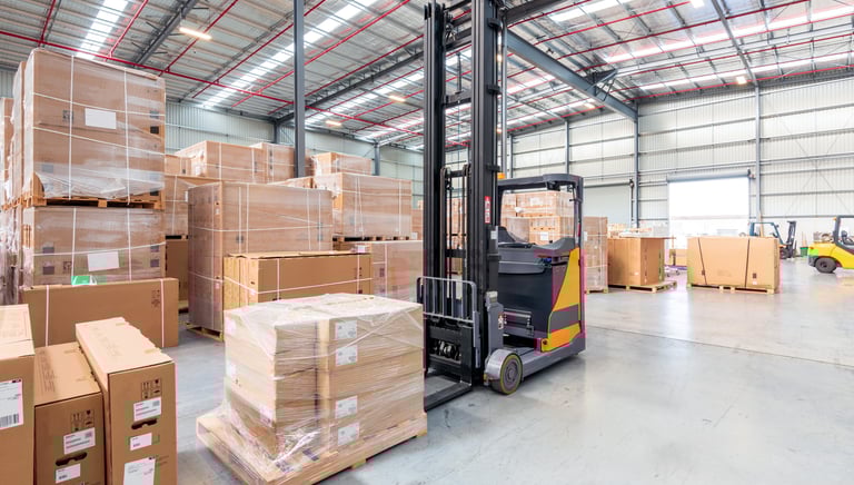 a forklift truck in a warehouse with boxes of boxes