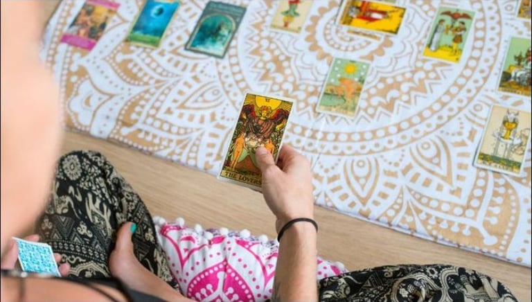 Una persona sostiene la carta del tarot "Los Amantes", durante una lectura terapeutica