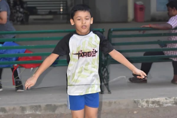 a young boy skateboarding on a sidewalk