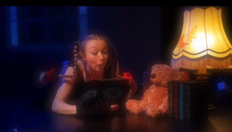 une petite fille regarde son livre de conte; elle rêve d'avoir des pouvoirs magiques