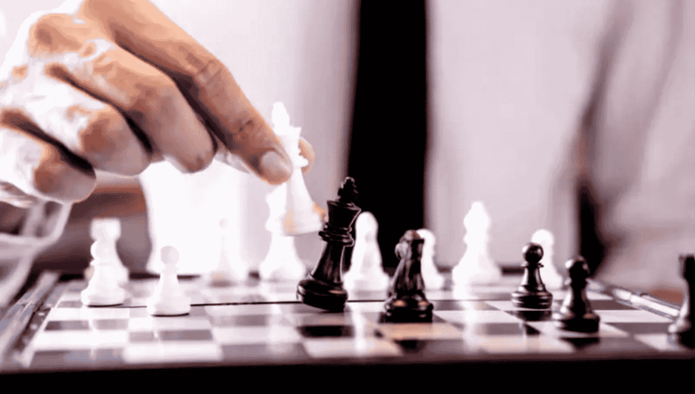 a man playing chess in a suit and tie