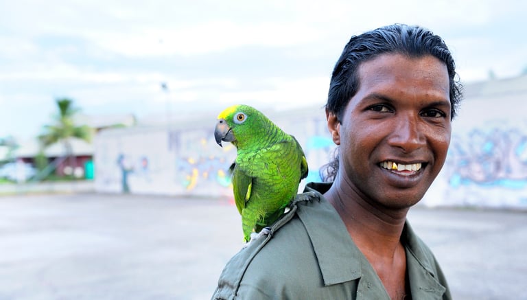Un homme et son perroquet prennent la pose devant l'appareil photo