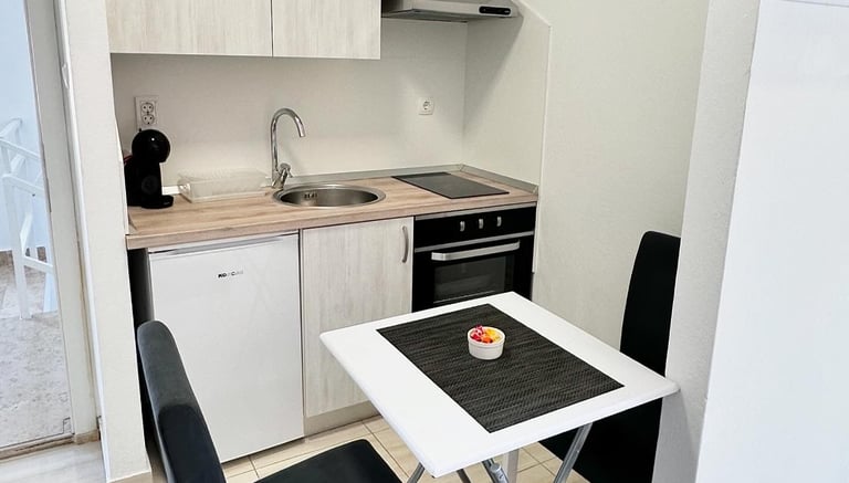 kitchen with coffe machine, fridge table and chairs