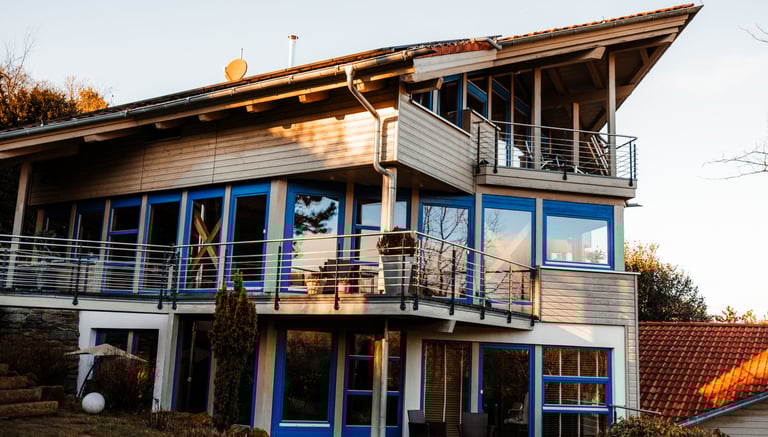 large wooden house with impressive window front and balconys
