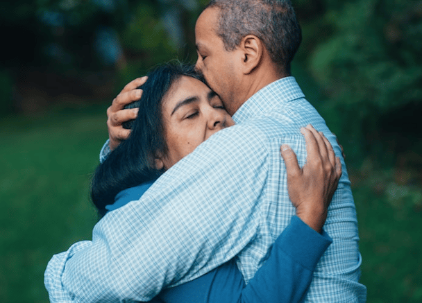 Couple cuddling looking sad