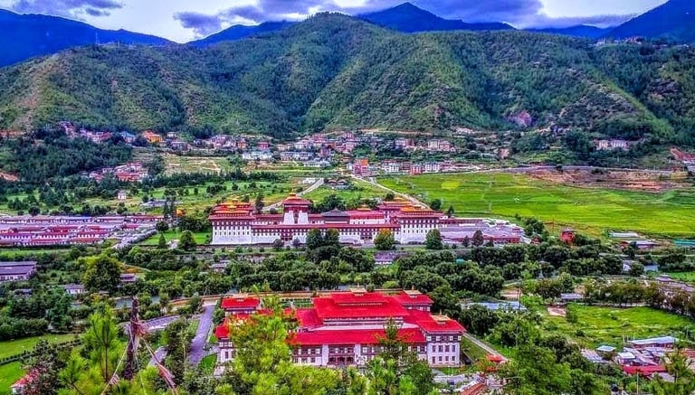 Trashichho-Dzong-Fortress-With-The-Backdrop-View-of-Green-Pristine-Mountain