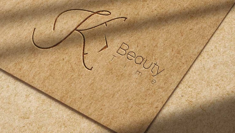 Elegant KT Beauty Time brand logo embossed on textured craft paper with natural leaf shadows.