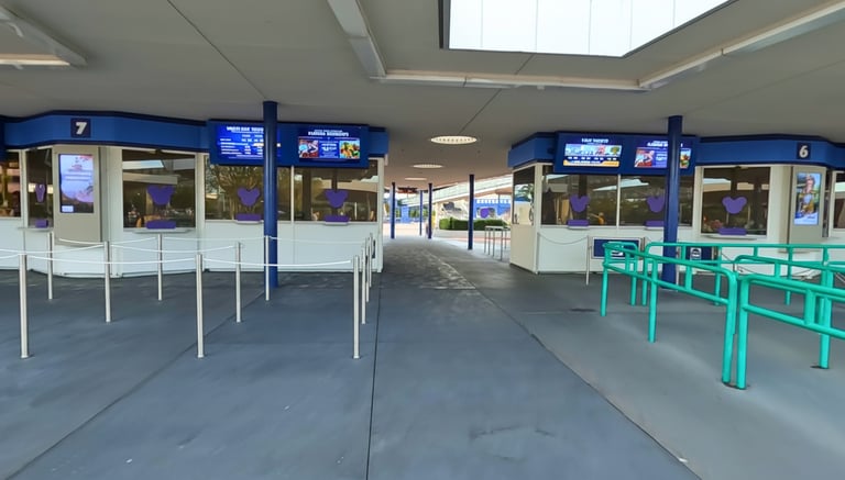 Disney World ticket windows with digital screens and queuing ropes at a park entrance