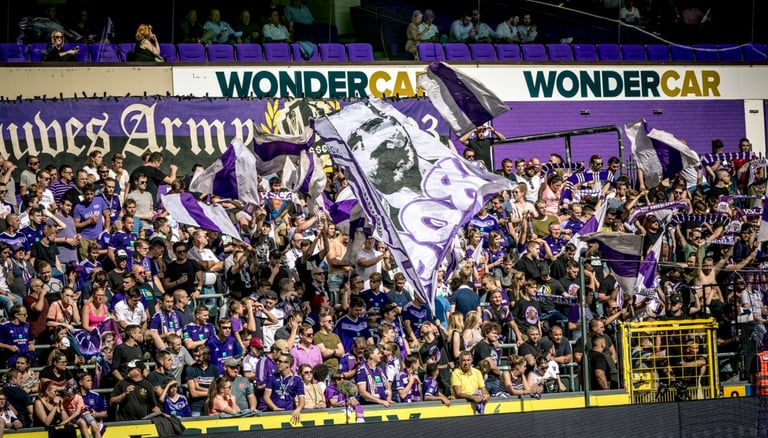 Fans des RSC Anderlecht in violett-weißen Farben beim Anfeuern im Stadion