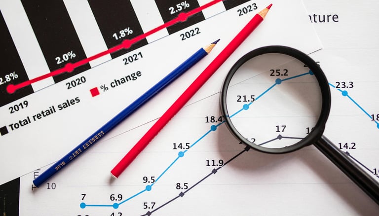 magnifying glass highlighting investing chart symbolizing gold market for precious metals