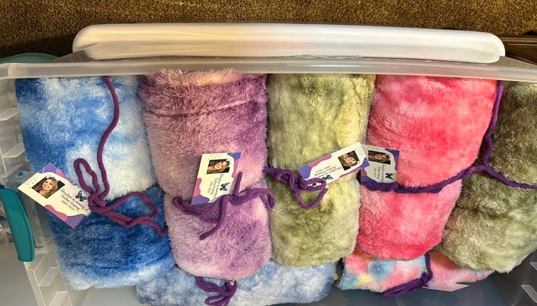 Colorful blankets in a clear tub