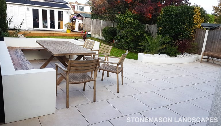 Modern chic raised porcelain patio with white rendered walls and planters