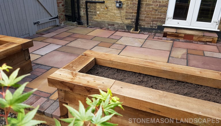Colourful sandstone patio with raised wooden timber planter seating