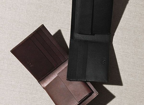 Carteras abiertas de cuero negro y marrón de dos pliegues con ranuras para tarjetas.