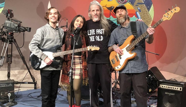 a group of people standing around a microphone and a guitar