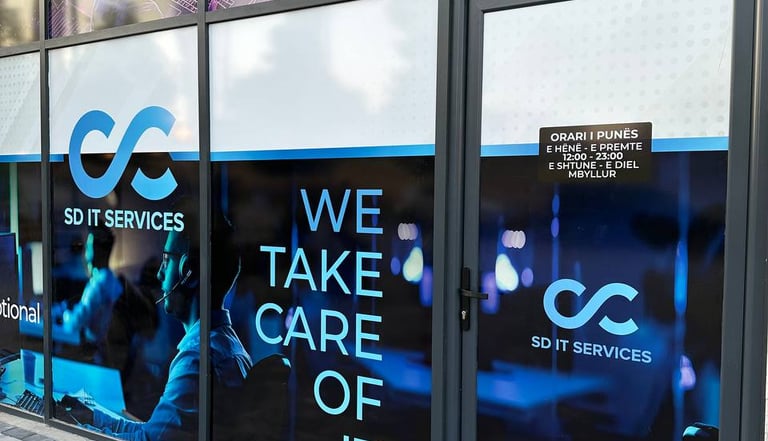 SD IT Services office storefront in Gjilan, Kosovo with branding highlighting 24/7 support and multi