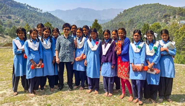Hanaru's founder, Kayoko Govindasamy standing with a group of girls who have just received Packs..