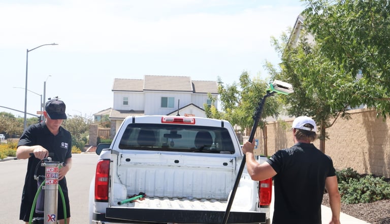 a man is cleaning a truck with a hose