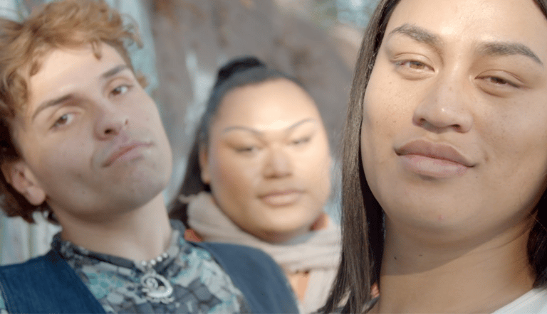 Three people gazing or smiling into the camera.