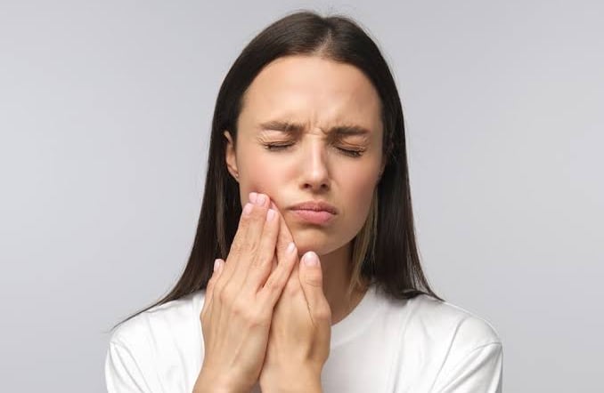 Physiotherapist performing jaw mobilization therapy for TMJ pain relief.