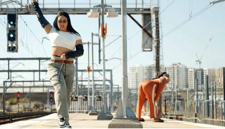 Two people looking fabulous and strutting on a train platform.