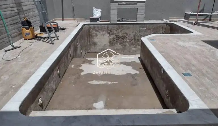 Proses pemasangan material finishing mozaik pada dinding kolam renang oleh tukang berpengalaman.