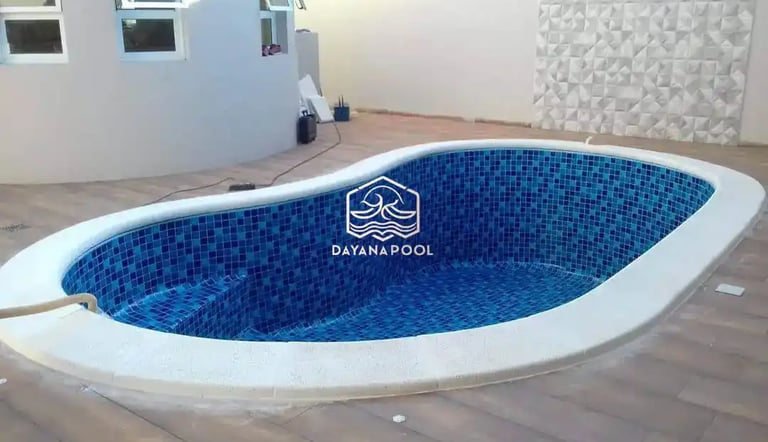 Proses pemasangan material finishing mozaik pada dinding kolam renang oleh tukang berpengalaman.