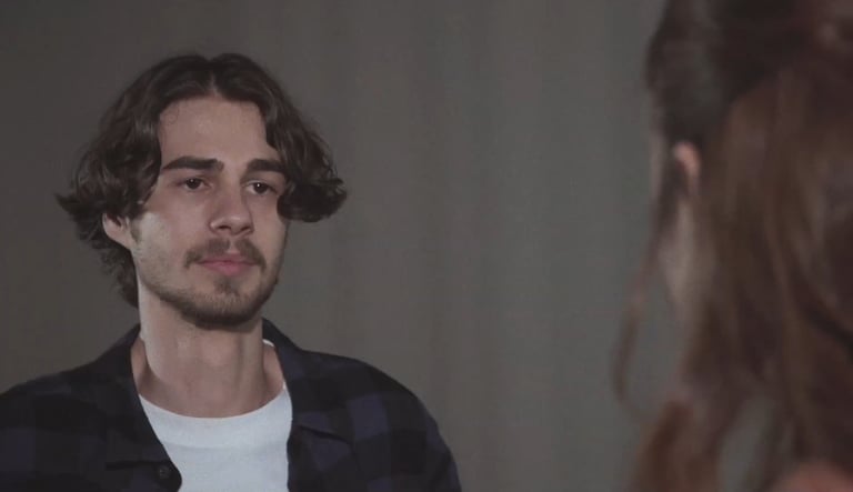 a man with a beard and a woman with a white shirt