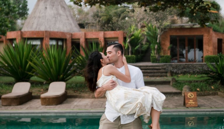 Intimate couple session at Waka Gangga Tabanan featuring groom lifting bride by the pool in West Bali luxury resort