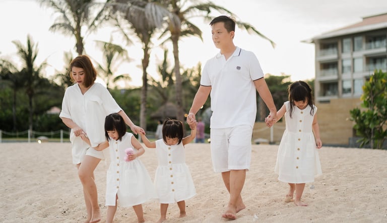 Family walking together along the beach at The Mulia Nusa Dua Bali during a relaxed family photography session