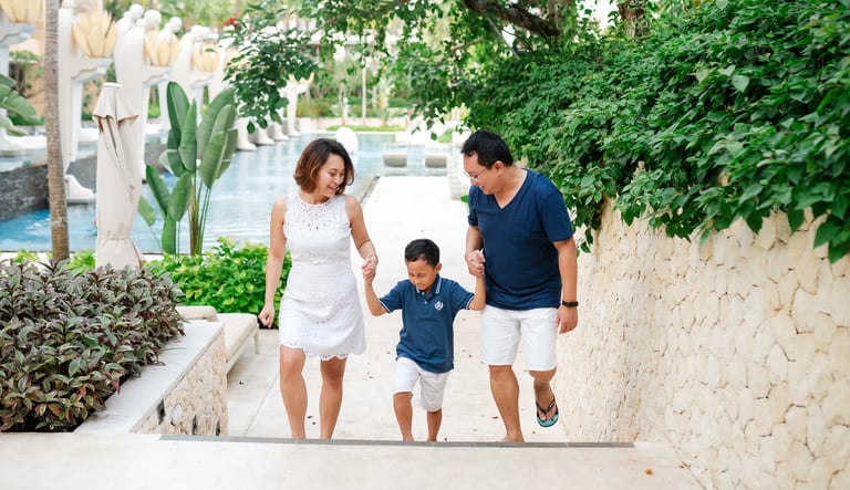 Family walking together on elegant resort stairs at The Mulia Nusa Dua Bali
