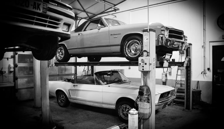 a car is parked on a lift in a garage, chevrolet, mustang